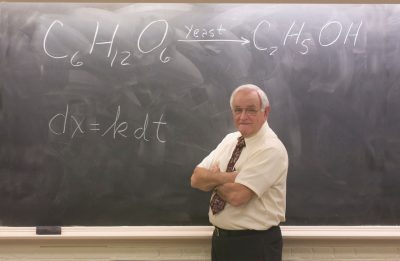 Jim Wightman stands in front of a chalkboard.