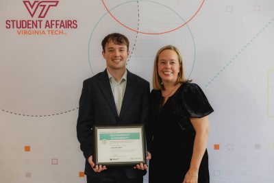 Two people posing with an award certificate.